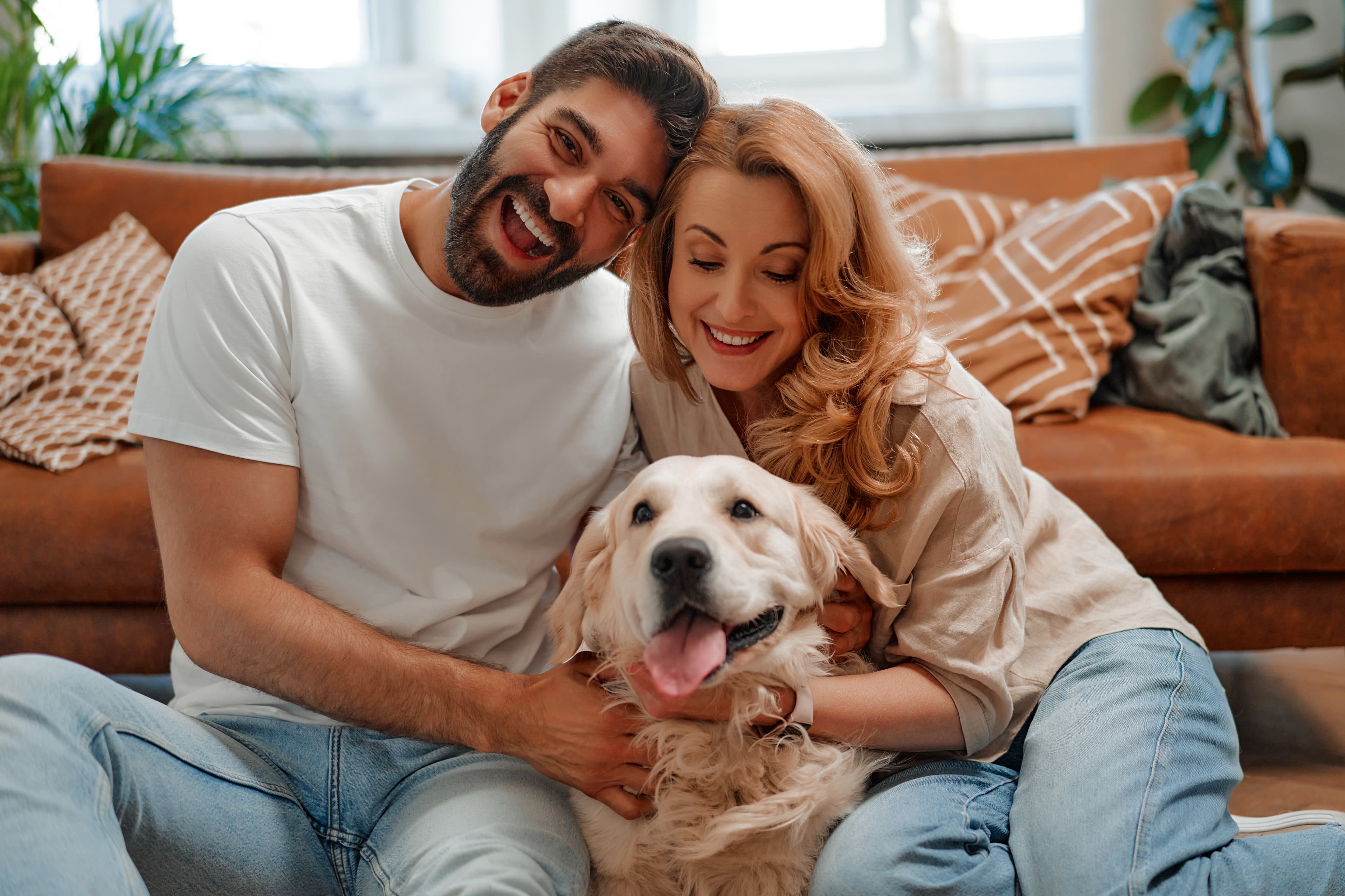 Couple relaxing at home with dog