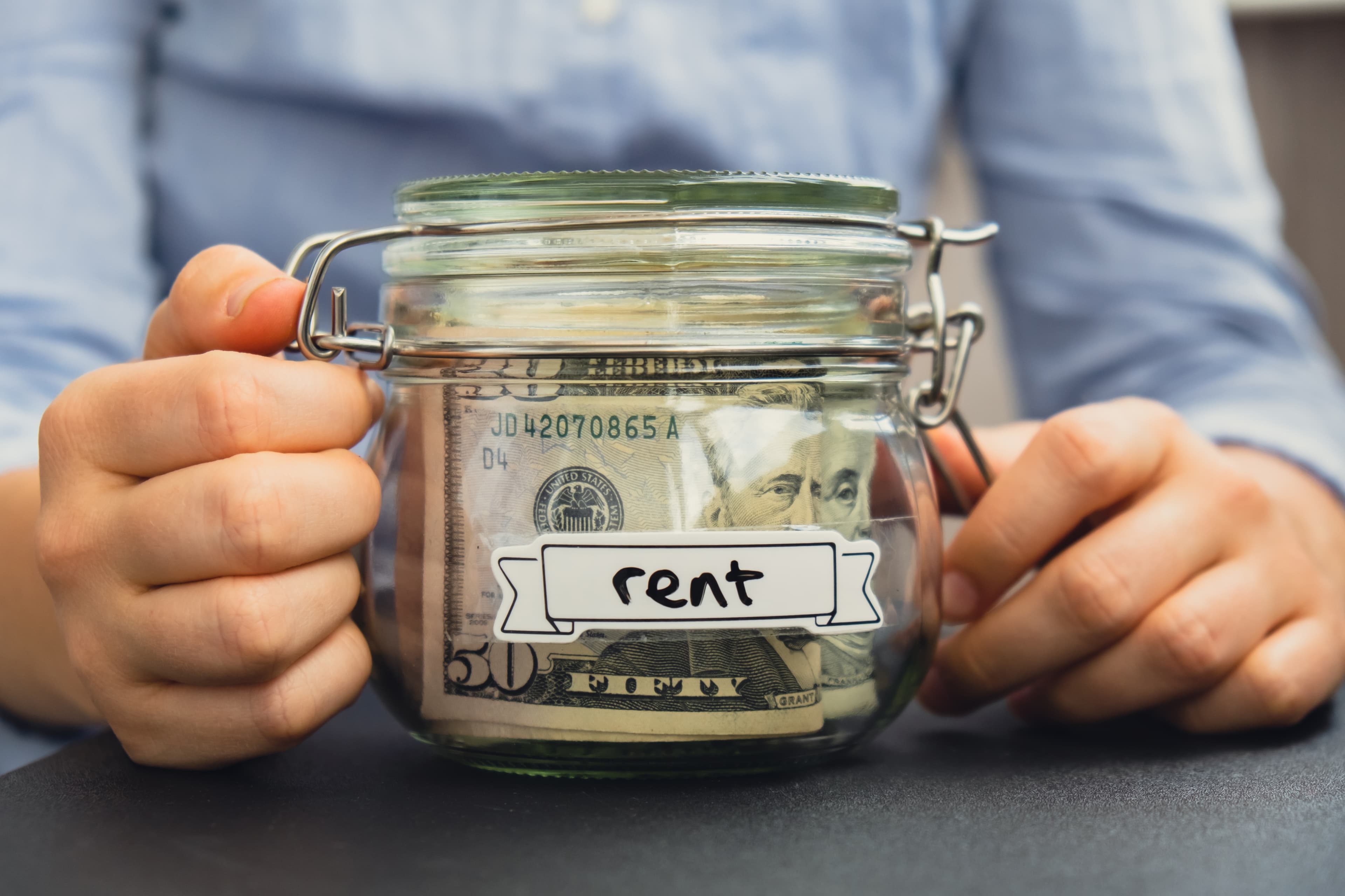 Hands holding glass jar full of savings