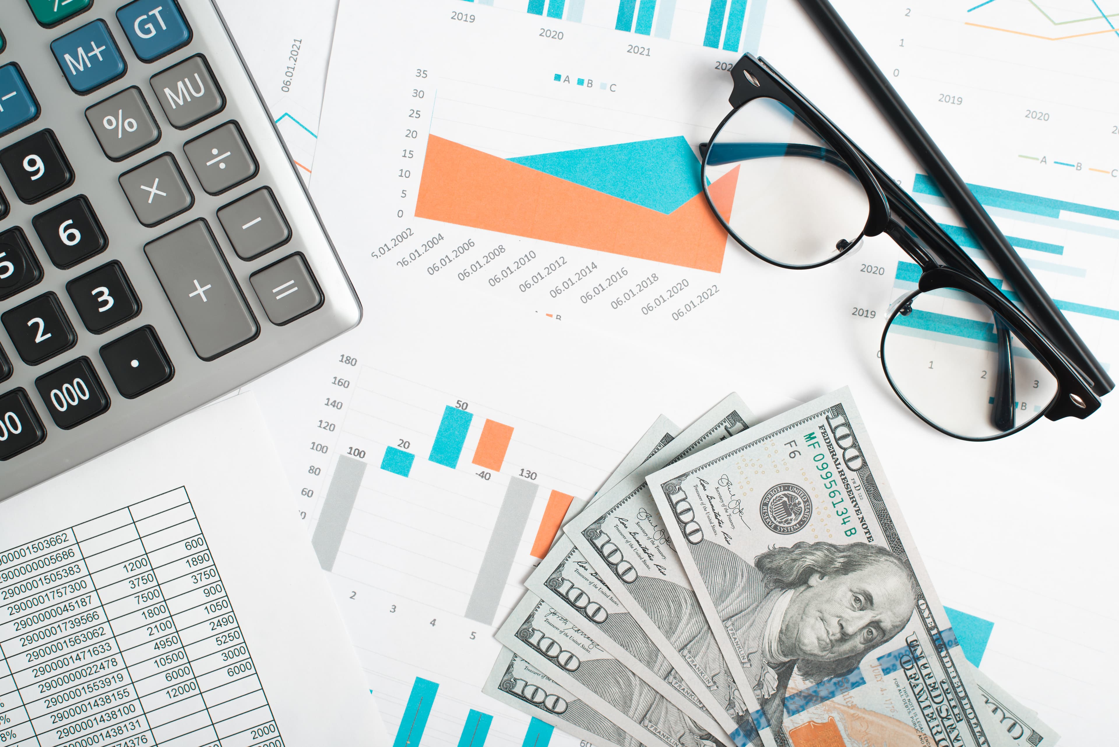 Financial documents with calculator and glasses