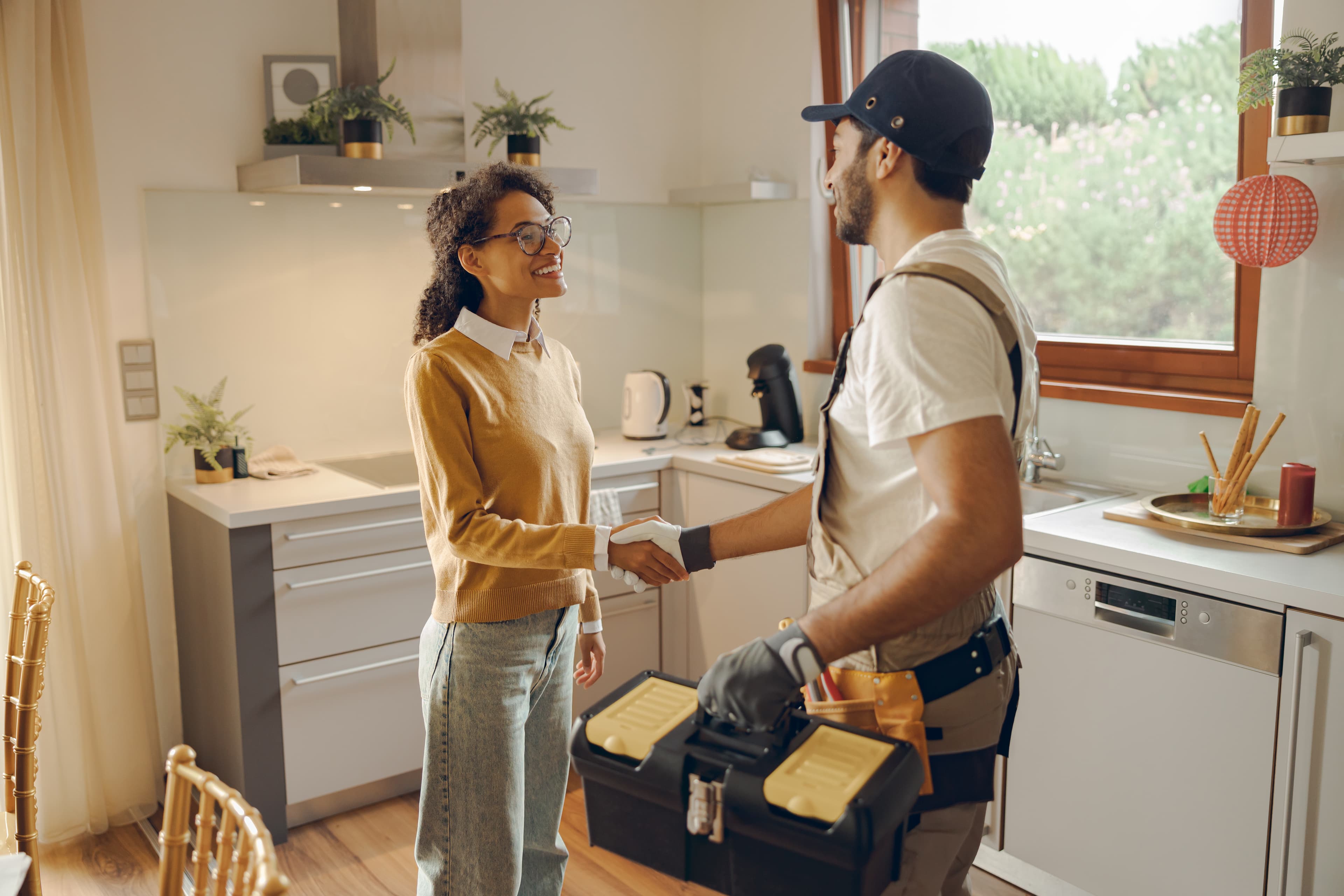 Professional repairman shaking hands with homeowner