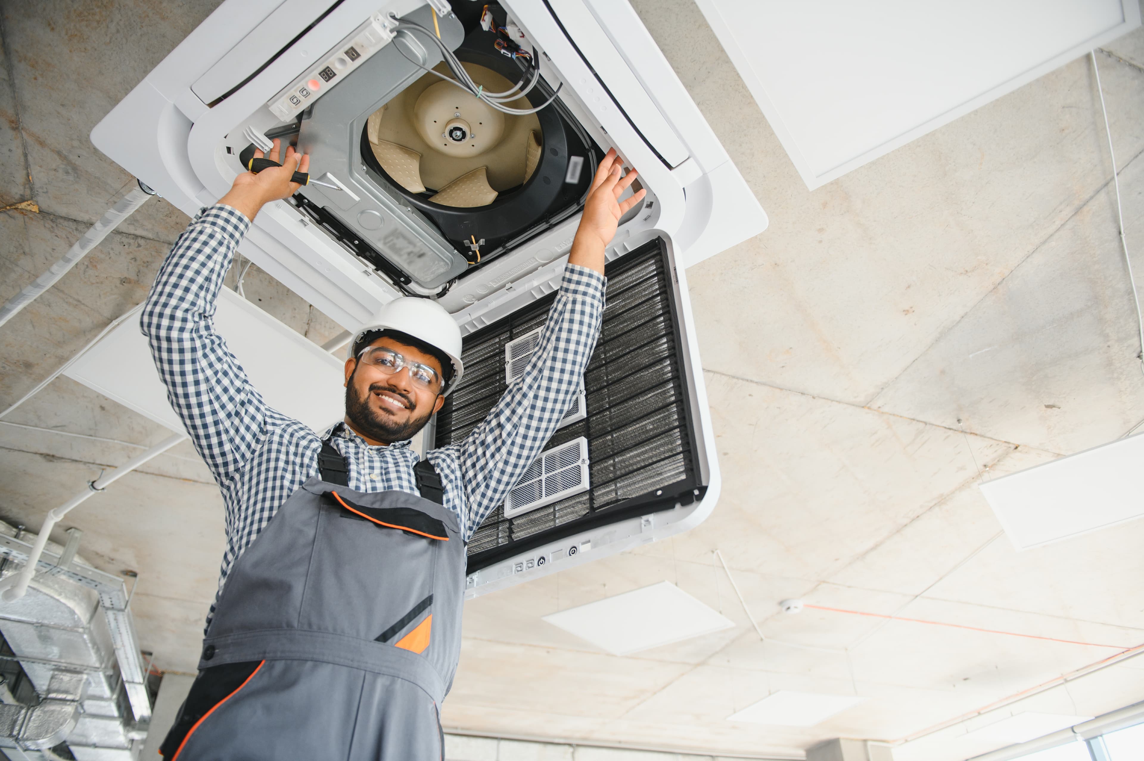 Technician maintaining modern air conditioner